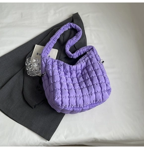 Detail of purple quilted bubble tote bag with square pattern and padded shoulder strap