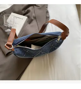 Interno spazioso della borsa denim con borchie a diamante e manico in pelle