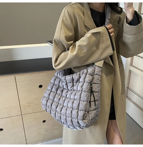 Detailed view of grey quilted cloud tote bag with pleated texture and wide strap
