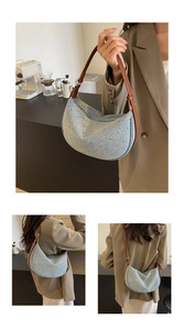 Dettaglio borsa a mezzaluna in denim azzurro con borchie e manico in pelle marrone