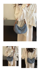 Dettaglio della borsa a mezzaluna in denim blu con strass e tracolla in pelle marrone