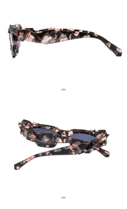 Dettaglio di occhiali da sole cat eye tartarugati con montatura geometrica a trama 3D