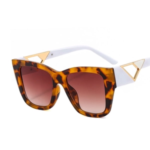 Square tortoiseshell sunglasses with white temples and gold triangle metal accents