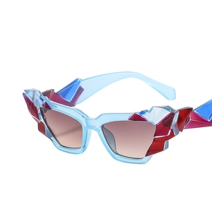 Occhiali da sole cat-eye moderni con montatura geometrica azzurra e decori rossi