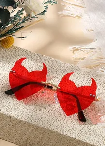 Detail of red heart-shaped devil horn sunglasses with a golden metal frame