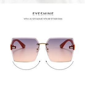 Detail of gradient purple lenses and golden flower metal accents on rimless sunglasses