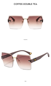 Detail view of coffee-gradient rimless sunglasses with gold floral accent on the temple