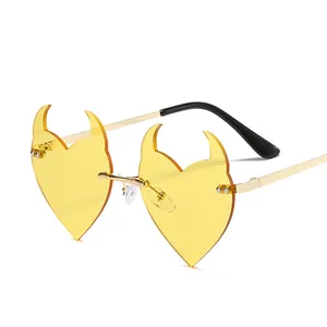 Unique devil heart sunglasses with yellow lenses and golden frames on white background