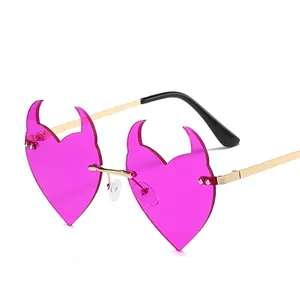 Pink heart-shaped devil horn sunglasses with gold metal frames and rimless lenses