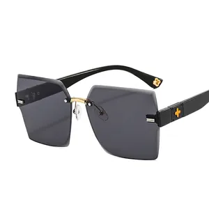 Fashionable rimless square sunglasses with dark grey lenses and gold clover details