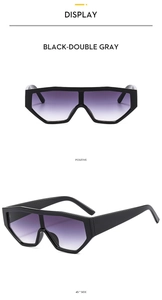 Detail view of black geometric oversized sunglasses with purple-gray gradient lenses