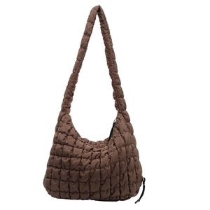 Detailed view of a brown quilted puffer shoulder bag featuring a soft textured bubble design.