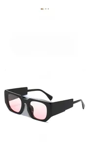 Détail de lunettes de soleil carrées à monture épaisse noire et verres roses