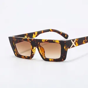 Retro square tortoiseshell sunglasses with dark gradient lenses and gold X hinge details
