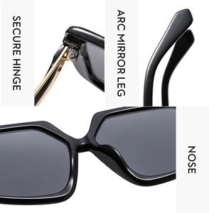 Detail view of gold hinges and ergonomic arc mirror legs on black butterfly sunglasses