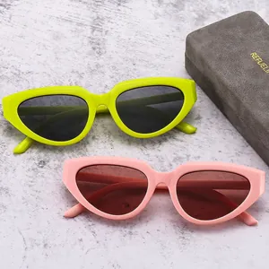 Y2K style chunky cat eye sunglasses in green and pink colors on marble background