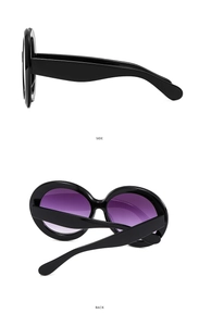 Detail view of oval sunglasses showing side temple design and back folded perspective
