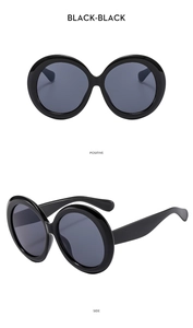 Front and side view of oversized round black sunglasses with dark grey lenses