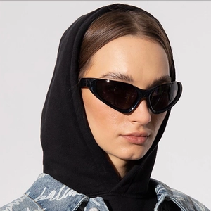 Y2K futuristic wraparound sunglasses with black cat-eye frame and dark lenses on model