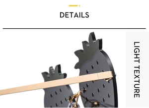 Détails des charnières dorées et verres noirs sur lunettes de soleil ananas fantaisie