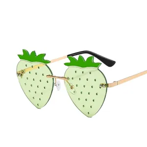 Lunettes de soleil sans monture en forme de fraise avec verres verts et métal doré