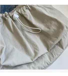 Close-up of light gray nylon drawstring bag showing fabric texture and plastic cord lock