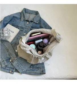 Spacious interior of beige pleated crossbody cloud bag showing large storage capacity