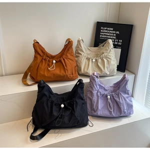 Detail of waterproof nylon crossbody bags in four colors on marble display stands