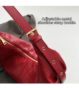 Detail of red leather dumpling bag with adjustable golden buckle and geometric texture