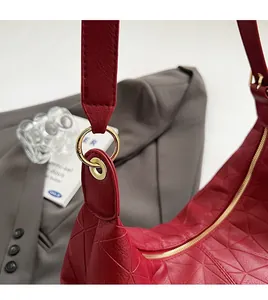 Macro shot of dark red geometric embossed PU leather bag with premium gold metal hardware