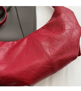 Detail shot of red PU leather bag with geometric triangle pattern and neat stitching