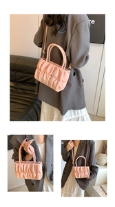 Detail shot of the pink pleated cloud bag texture and detachable shoulder strap on a model