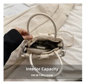 Spacious interior of beige pleated cloud bag showing storage for phone and cosmetics