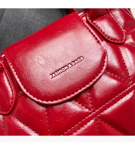 Detailed close-up of dark red quilted leather bucket bag with fashion logo and rhombic texture