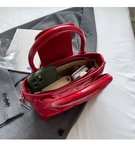 Top view showing the spacious interior and inner zipper pocket of the red quilted bucket bag
