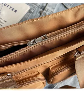Detail of silver metal zipper and brown nylon fabric on a large capacity tote bag