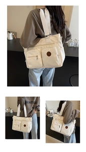 Detail of cream canvas tote bag showing dual front zip pockets and large storage space