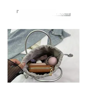 Vue de dessus de l'intérieur du sac seau argenté avec portefeuille et cosmétiques