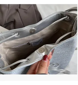 Detail of silver bucket bag interior with magnetic closure and premium satin lining