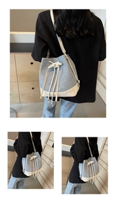 Detail of contrast bucket bag featuring drawstring closure and textured fabric material