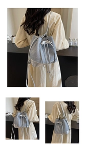 Detail of silver bucket bag with drawstring bow and versatile crossbody strap design