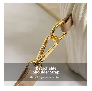 Détail du fermoir mousqueton doré et de la bandoulière amovible en cuir beige