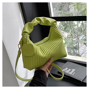 Détail du sac bandoulière plissé vert avec poignée nuage assortie et étiquette en cuir
