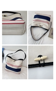 Detail of canvas bucket bag featuring blue stripes and a vintage wooden toggle closure