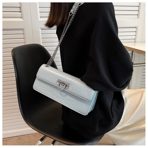 Light blue faux crocodile skin shoulder bag with silver chain strap shown on model