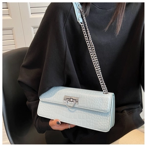 Close-up of mint blue crocodile pattern leather bag with silver metal ring lock and chain