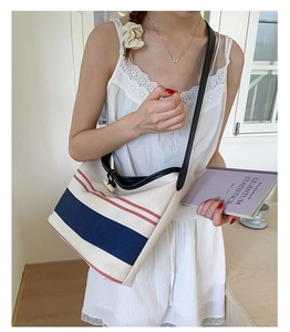Detail of canvas tote bag with nautical stripes and wooden toggle closure