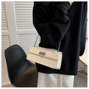 Detail view of cream crocodile texture shoulder bag with silver chain and metal lock