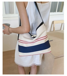 Detail of canvas beach tote showing navy stripes and decorative horn button closure