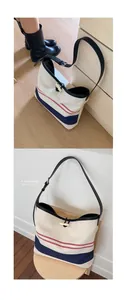 Detail of striped canvas tote bag with contrast straps and cream horn button closure